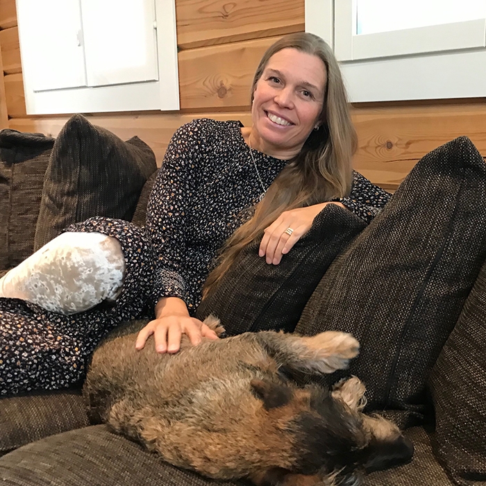 Hanna-reetta Metsänheimo istuu sohvalla koiransa kanssa.